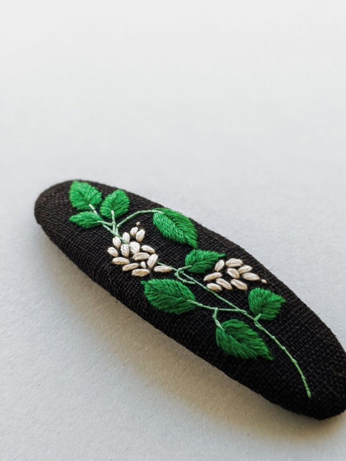 Détail barrette à cheveux motif fleur brodé à l'aiguille